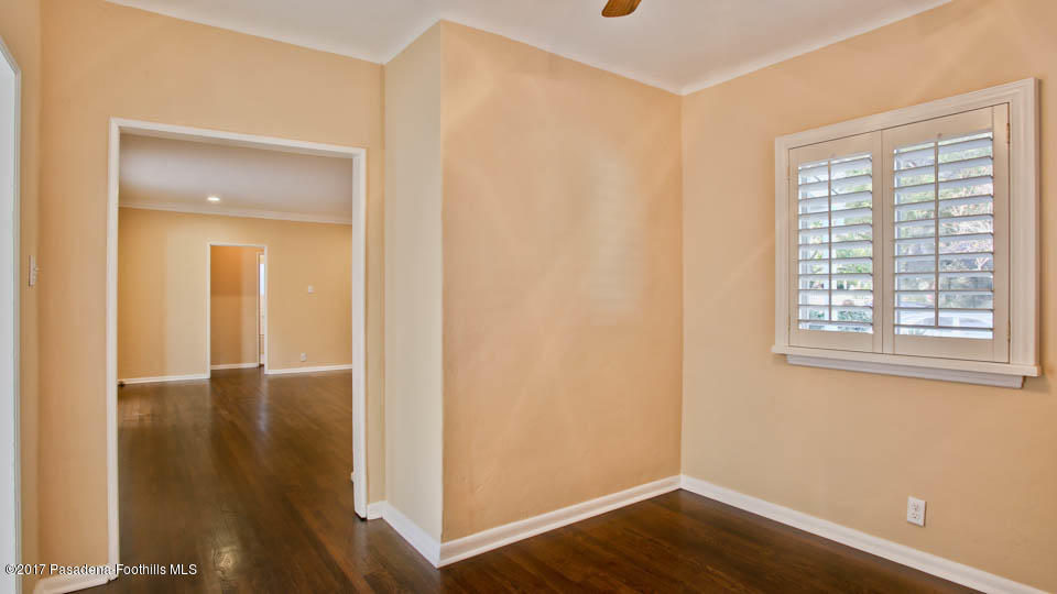 330 Fillmore Street Pasadena, CA 91106 - Photo 8 of 25 an empty room with wooden floor and windows with curtains