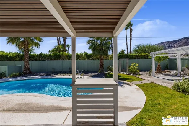 a view of a swimming pool with a lounge chair and palm trees