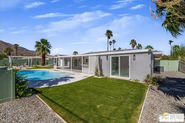 a view of a house with backyard and sitting area