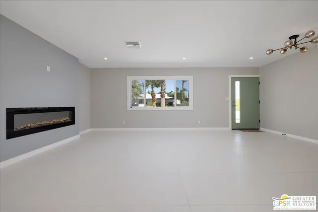 an empty room with windows and fireplace