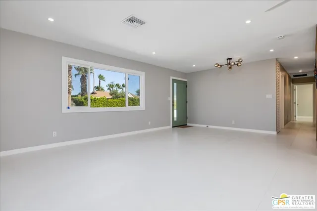 an empty room with windows and painted walls