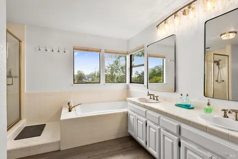 a bathroom with a granite countertop sink mirror and a bathtub