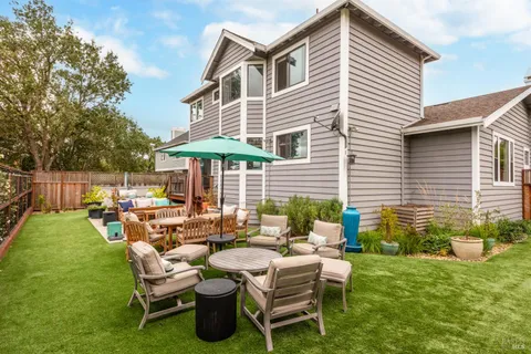a view of a house with backyard and sitting area