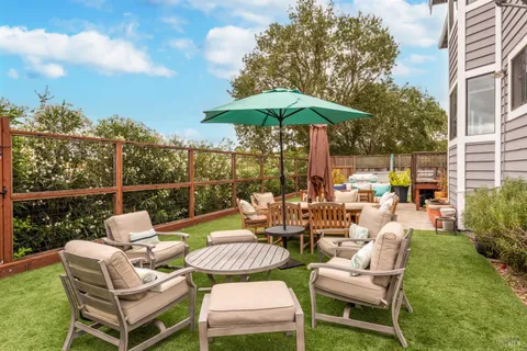 a view of a patio with a table chairs and a backyard