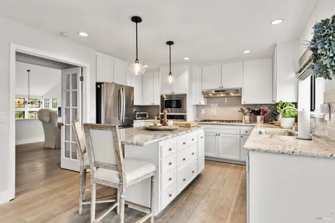 a kitchen with stainless steel appliances kitchen island granite countertop a kitchen island hardwood floor sink stove and granite counter top