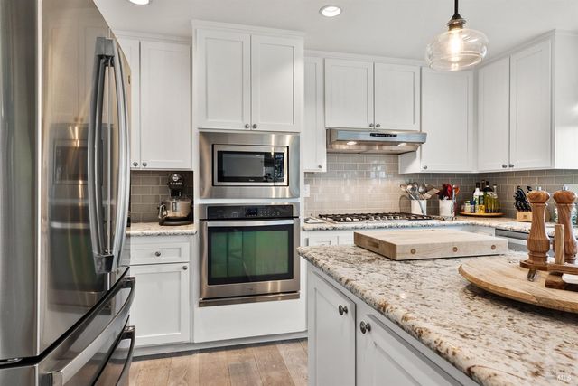 a kitchen with stainless steel appliances granite countertop a stove a refrigerator and a sink