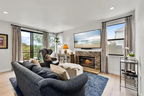 a living room with fireplace furniture and a floor to ceiling window
