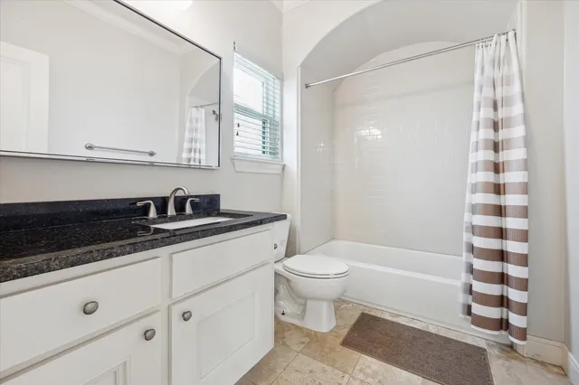 a bathroom with a sink a toilet a mirror and shower