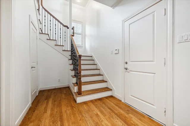 a view of a hallway with wooden floor and entryway