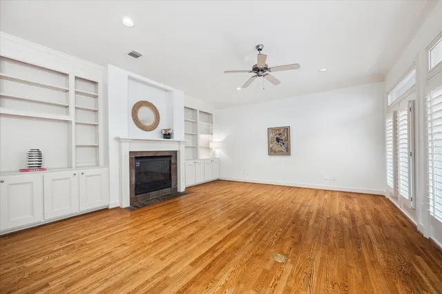 a view of empty room with wooden floor and fireplace