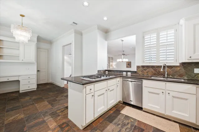 a kitchen with granite countertop a sink stove and cabinets