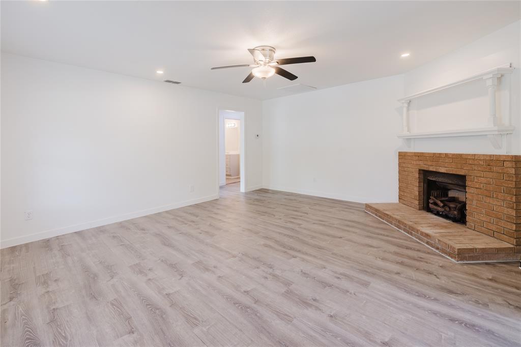 524 West Roberts Street Gorman, TX 76454 - Photo 6 of 35 a view of empty room with wooden floor and fireplace