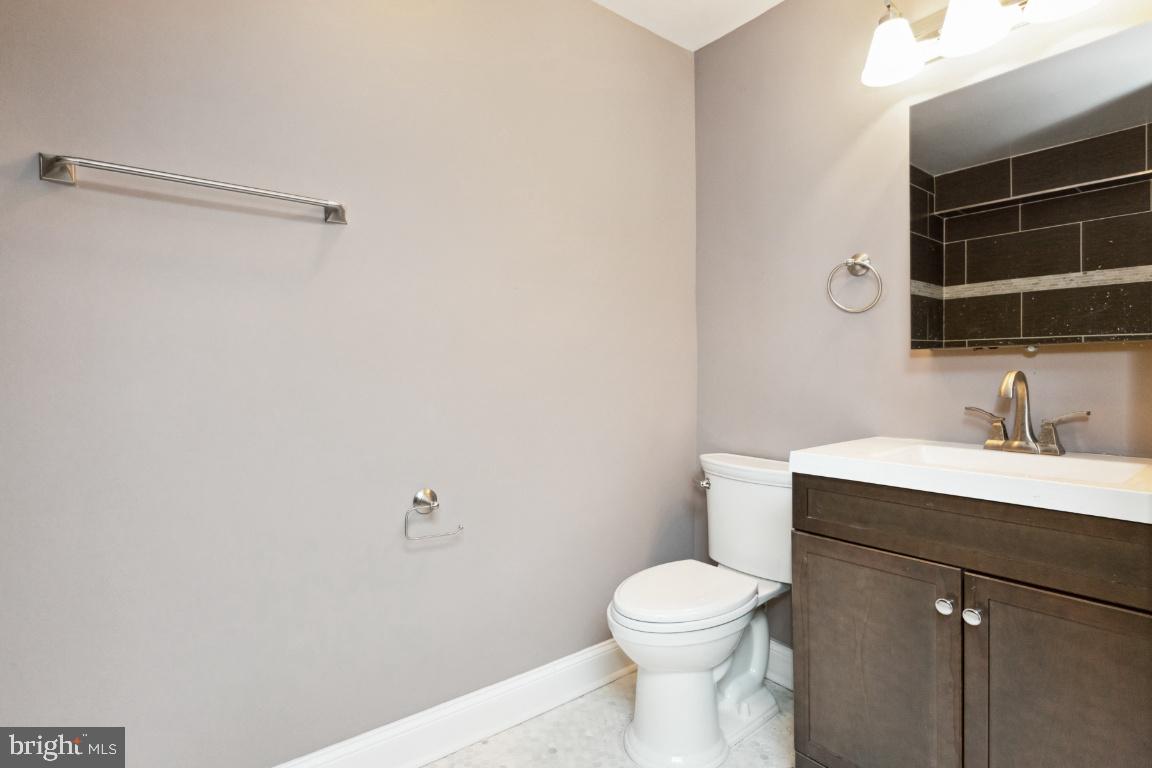 3900 14th Street Northwest, Unit 103 Washington, DC 20011 - Photo 16 of 29 a bathroom with a toilet a sink a vanity and mirror