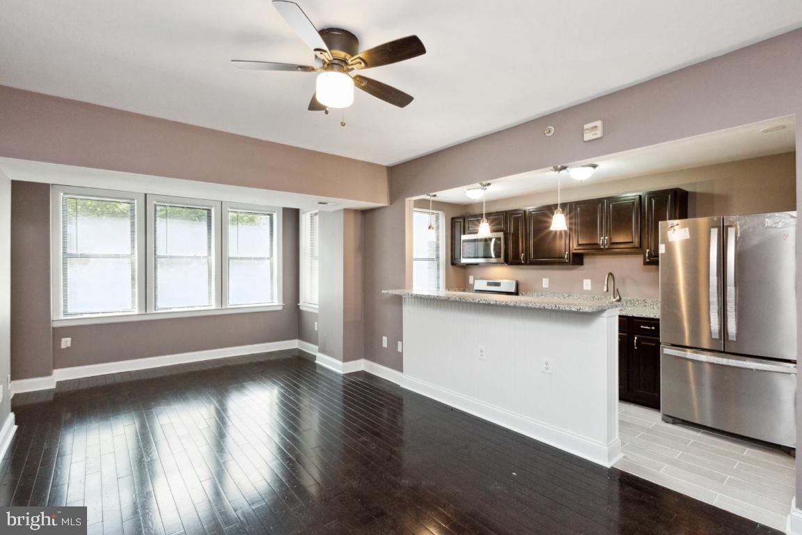 3900 14th Street Northwest, Unit 103 Washington, DC 20011 - Photo 2 of 29 a kitchen with stainless steel appliances granite countertop a refrigerator a sink dishwasher a stove and a wooden floor