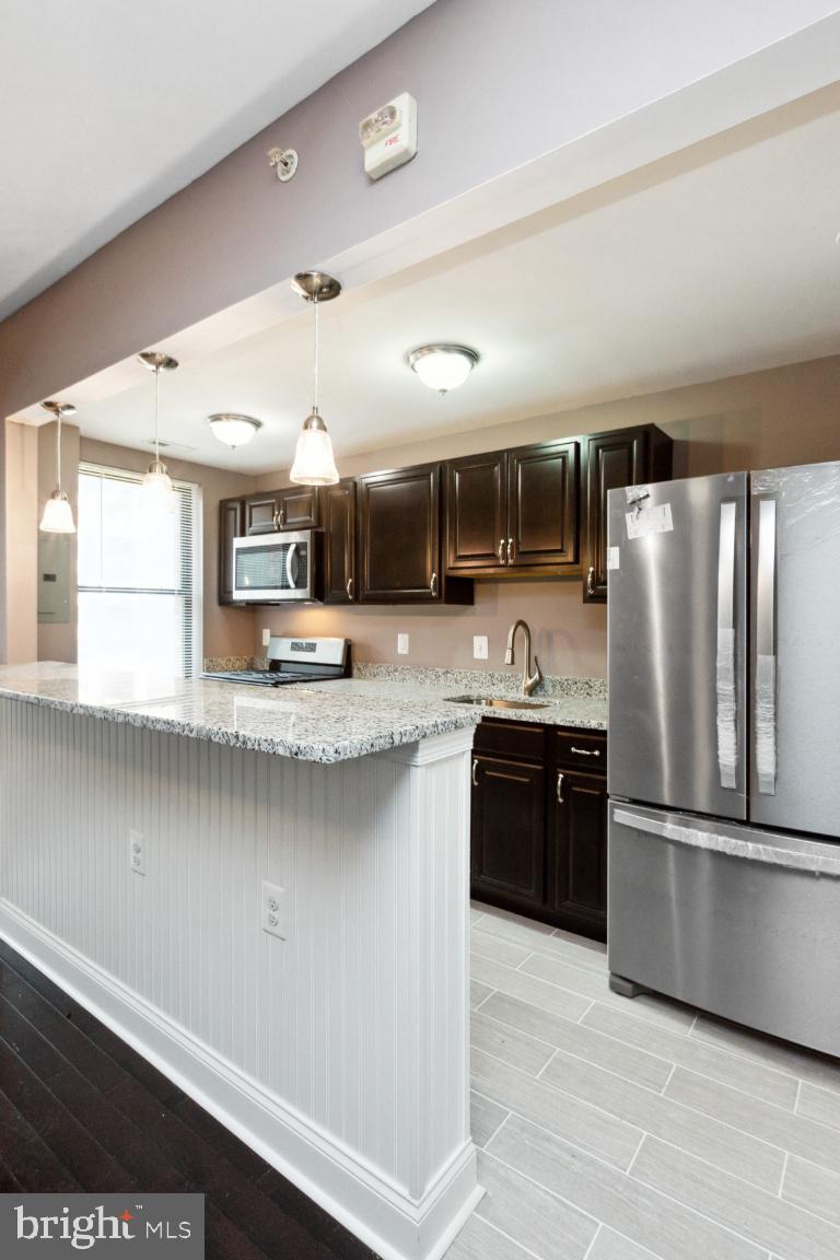 3900 14th Street Northwest, Unit 103 Washington, DC 20011 - Photo 10 of 29 a kitchen with stainless steel appliances granite countertop a refrigerator a sink and a stove