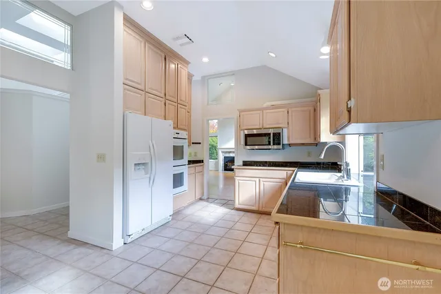 a kitchen with stainless steel appliances granite countertop a refrigerator sink and cabinets