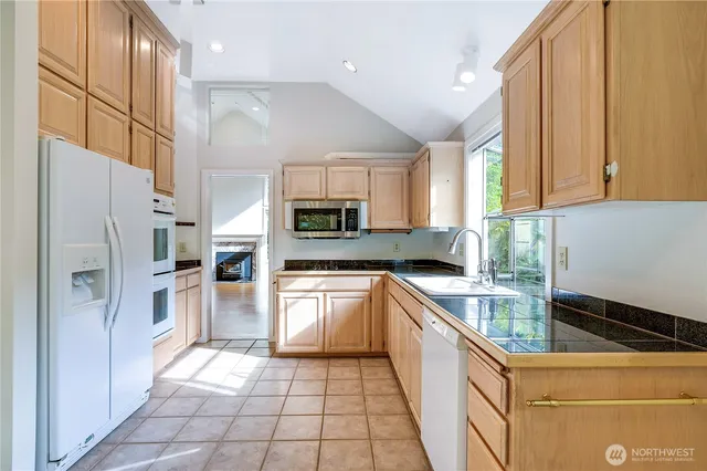 a kitchen with a refrigerator a sink and a stove top oven