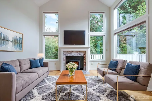 a living room with furniture a large window and a fireplace