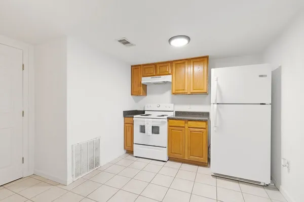 a kitchen with stainless steel appliances granite countertop a refrigerator sink and white cabinets