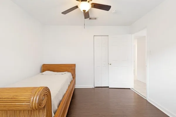 a view of a bedroom with a bed and a chandelier fan