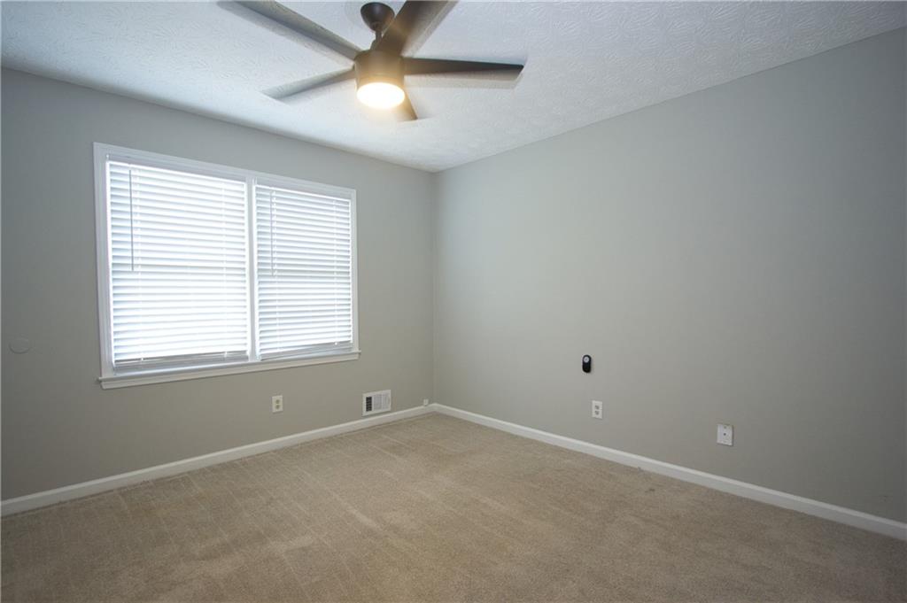 374 McGiboney Road Covington, GA 30016 - Photo 24 of 29 an empty room with a window and a fan