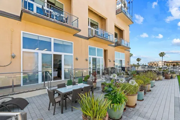 a view of a patio with couches table and chairs and potted plants