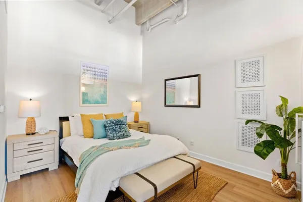 a bedroom with a bed potted plant with the wooden floor