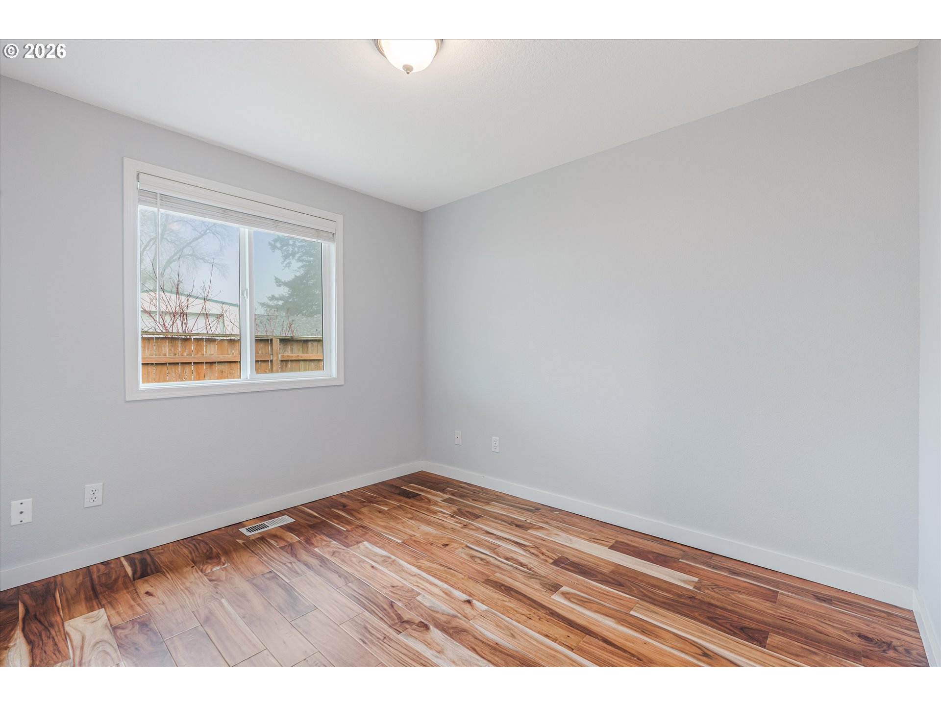 1615 Lilly Court Newberg, OR 97132 - Photo 19 of 30 a view of an empty room with wooden floor and a window