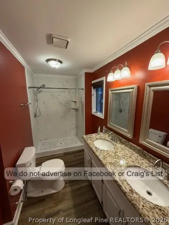 a bathroom with a granite countertop sink a mirror and shower