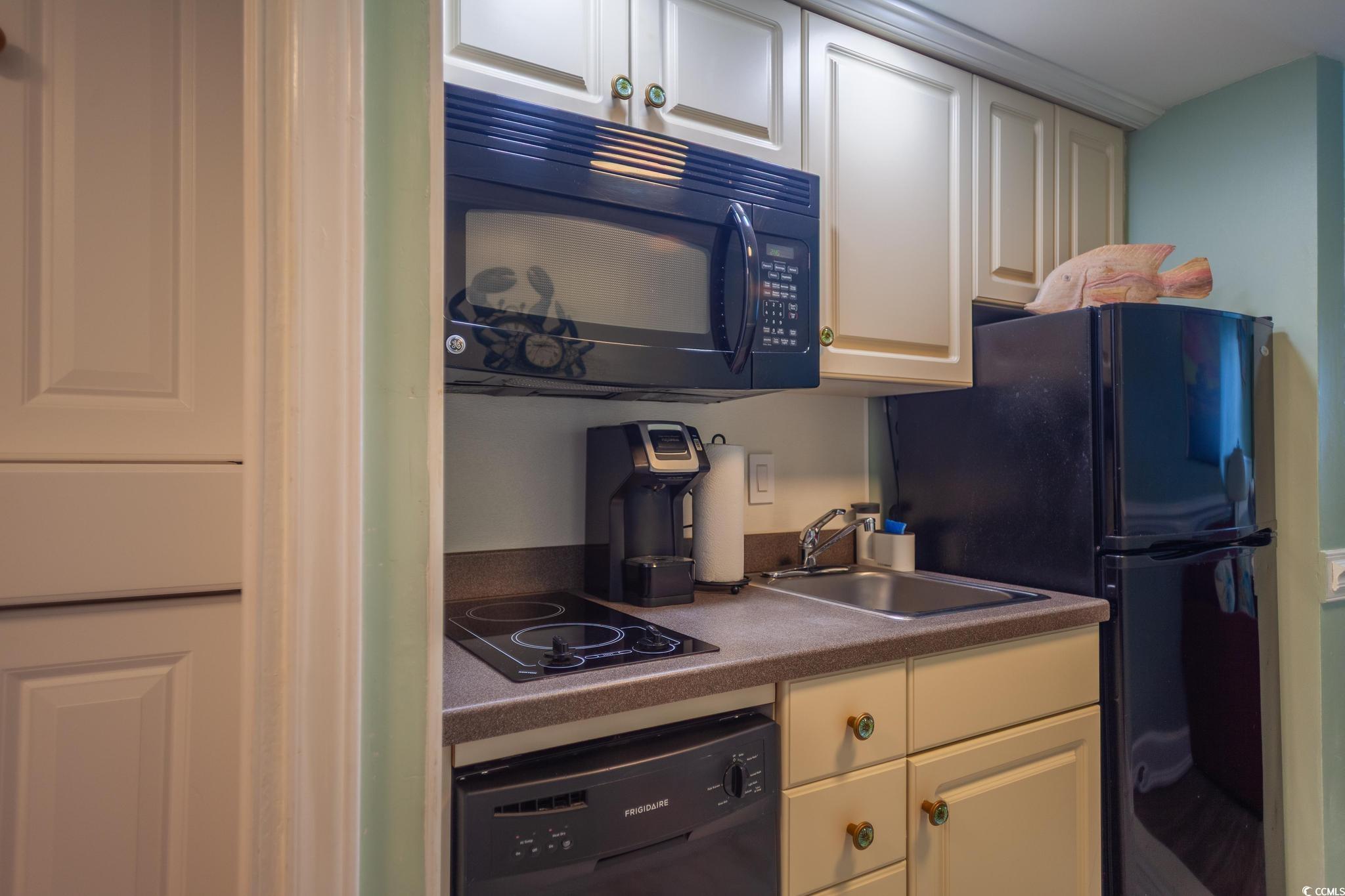 9550 Shore Drive, Unit 1728 Myrtle Beach, SC 29572 - Photo 9 of 36 Kitchen featuring black appliances and white cabinets