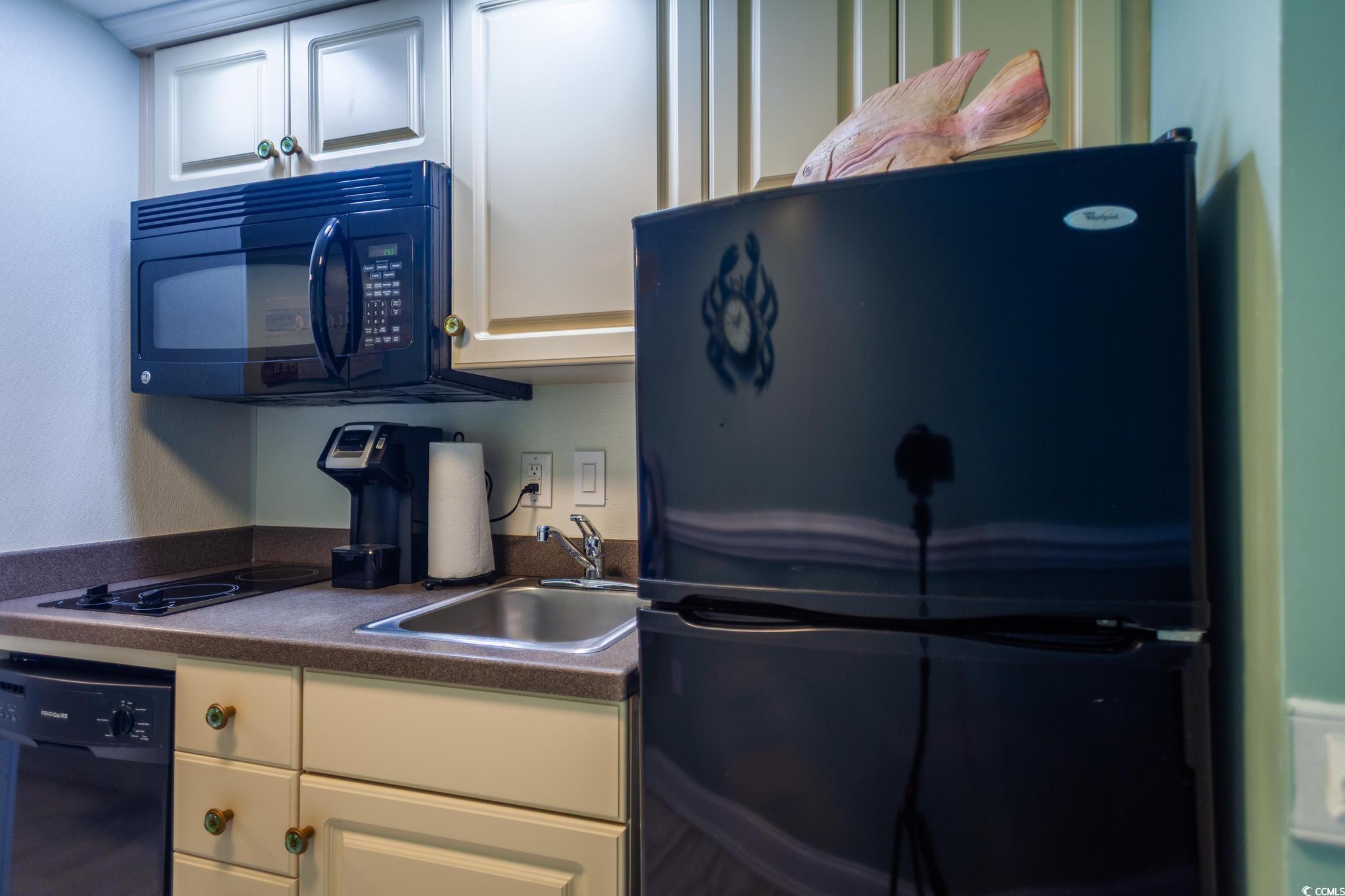 9550 Shore Drive, Unit 1728 Myrtle Beach, SC 29572 - Photo 10 of 36 Kitchen with black appliances, dark countertops, and white cabinets