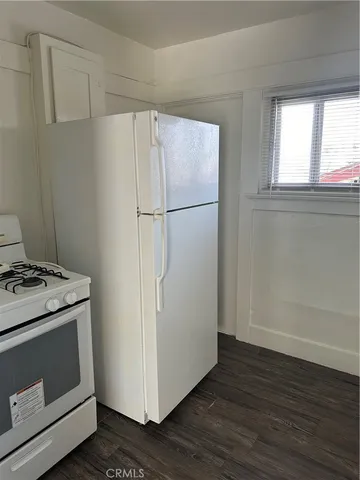 a view of a kitchen with a stove fridge and wooden floor