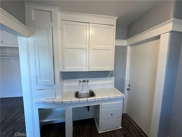 a room with a sink cabinets and wooden floor