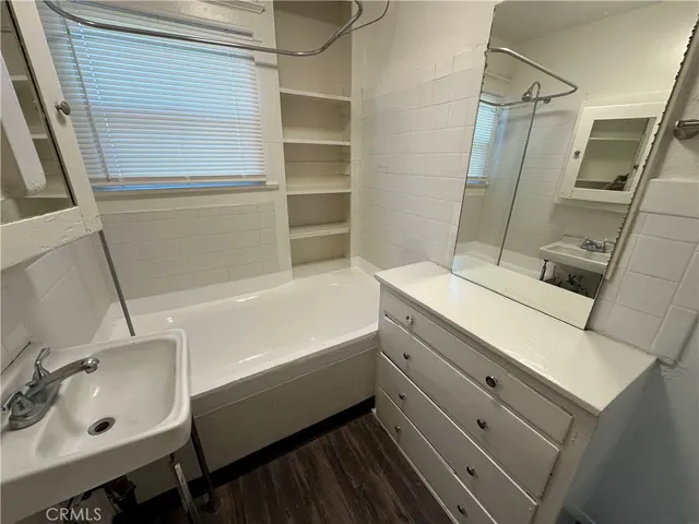 a bathroom with a tub sink and mirror