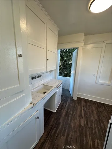 a kitchen with a sink and wooden floor