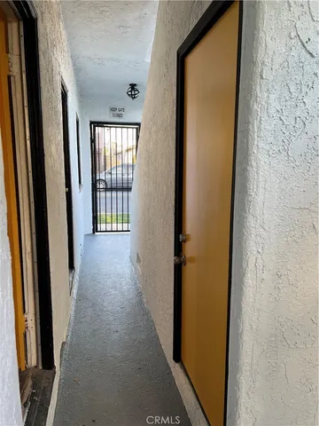 a view of a hallway with wooden floor and windows