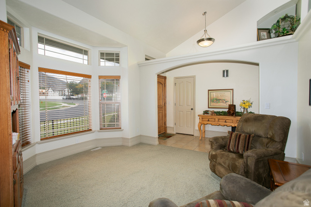 426 Deer Hollow Road Tooele, UT 84074 - Photo 3 of 37 Living room featuring light carpet, high vaulted ceiling, and light tile patterned floors