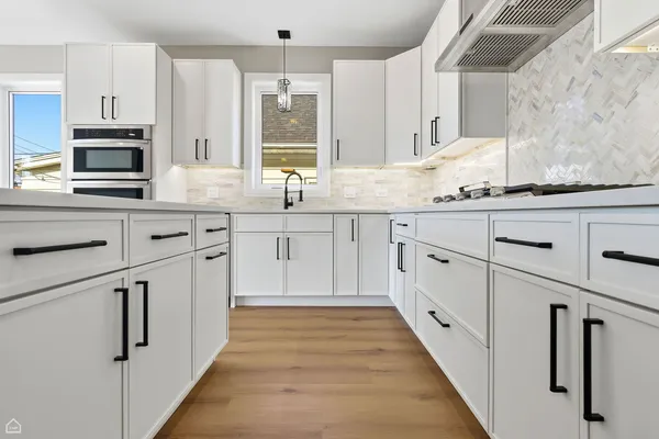 a kitchen with granite countertop white cabinets and stainless steel appliances