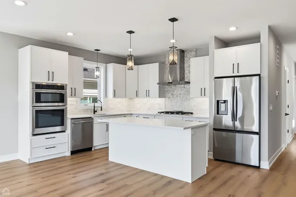 a kitchen with stainless steel appliances a refrigerator and a stove top oven