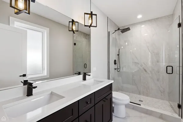 a bathroom with a sink a toilet and shower