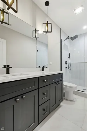 a bathroom with a double vanity sink toilet and shower