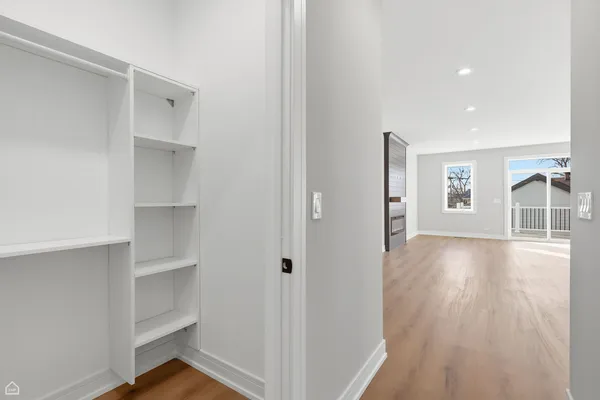 a view of empty room with wooden floor and windows