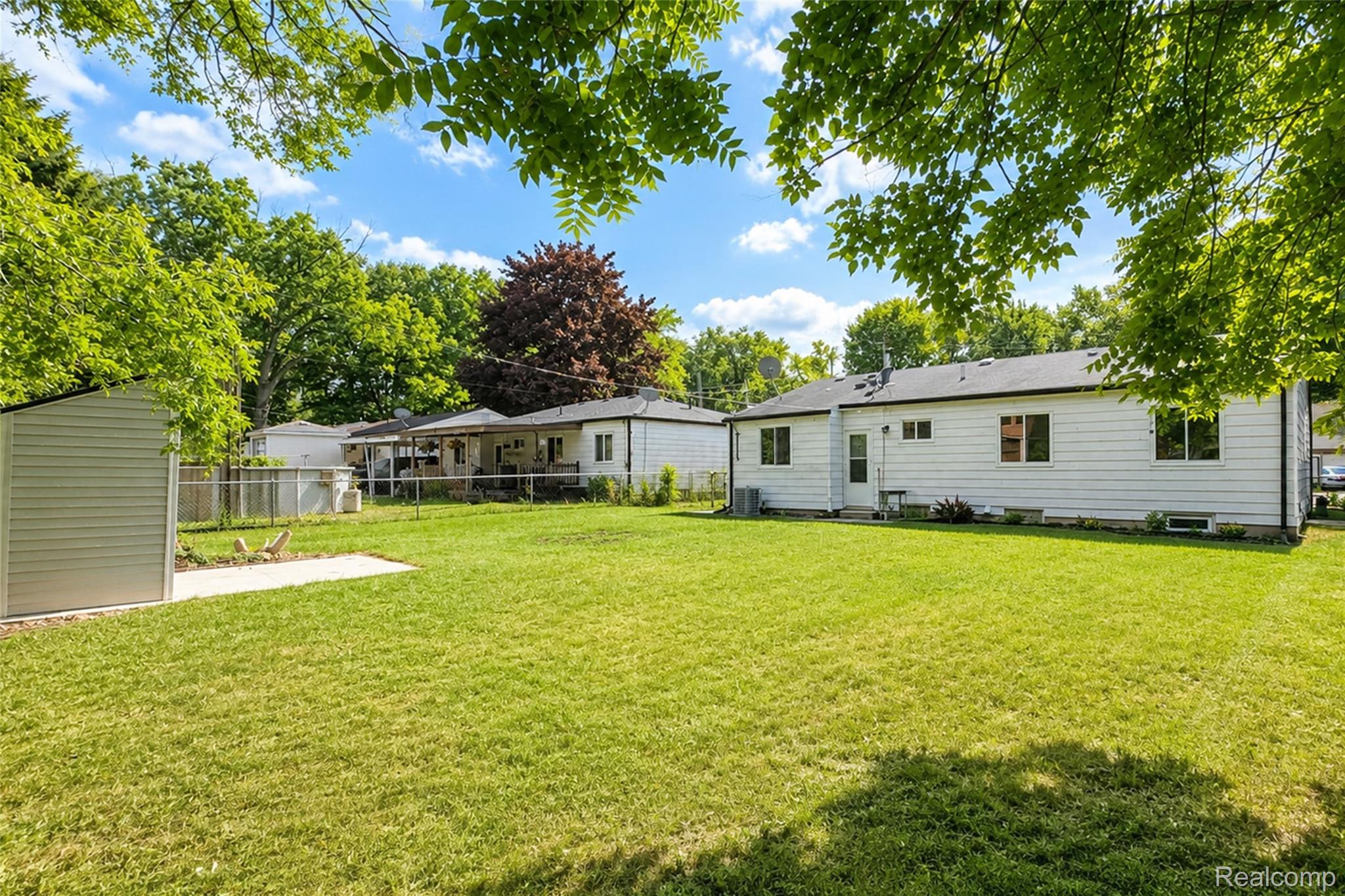 201 Cardwell Street Inkster, MI 48141 - Photo 8 of 41 Expansive backyard featuring a manicured lawn, a detached storage shed, a concrete patio, and mature trees