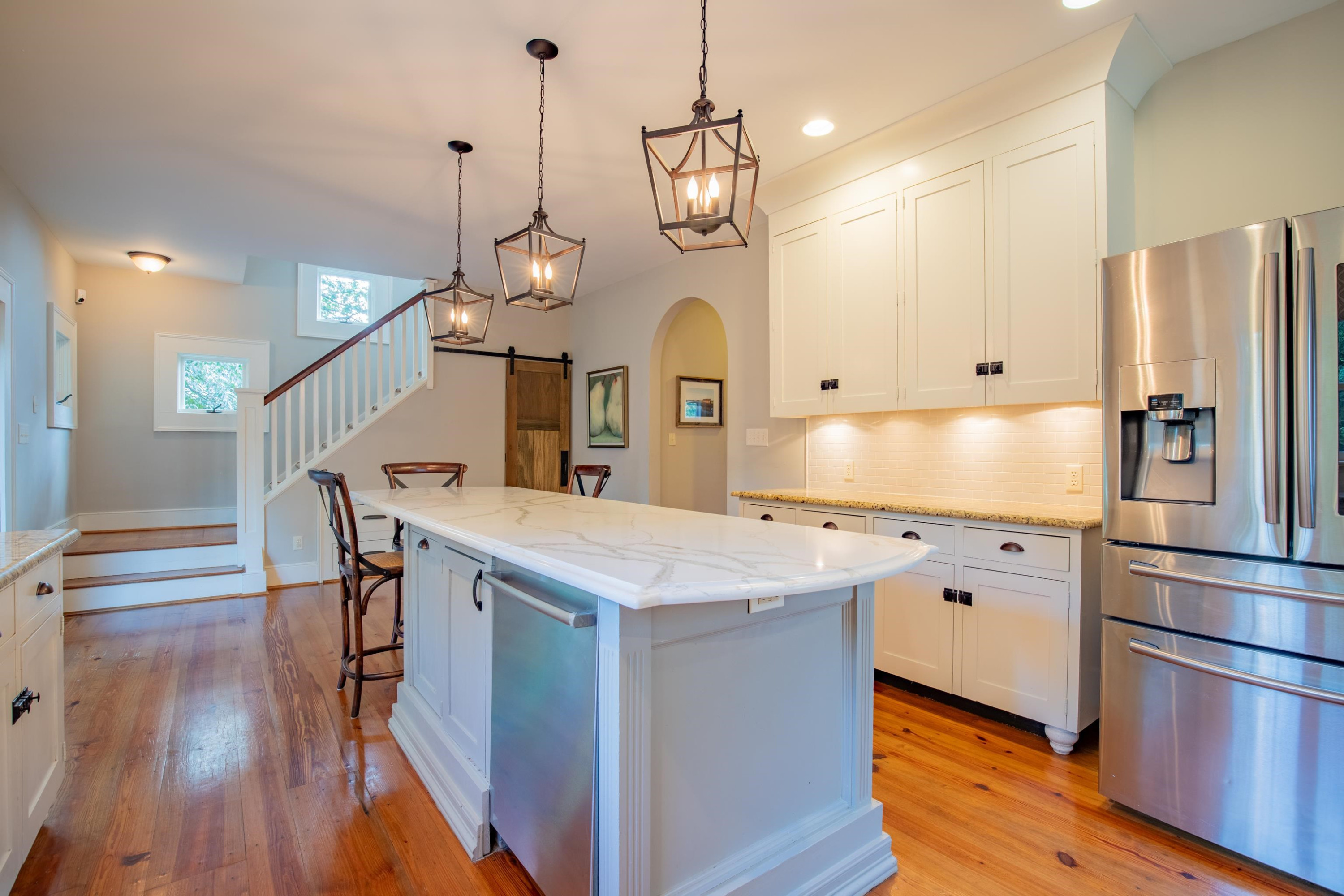616 Mills Street Raleigh, NC 27608 - Photo 8 of 30 a kitchen with stainless steel appliances granite countertop a refrigerator a sink dishwasher a stove and a dining table with wooden floor