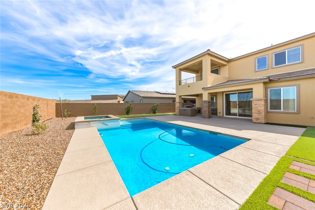 290 Rusty Ridge Lane Henderson, NV 89015 - Photo 41 of 61 Backyard w/pool & spa, desert rock w/synethic grass & pavers, built in outdoor kitchen w/fridge, cooktop & sink & No Rear Neighbors.