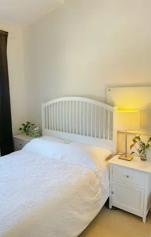 a spacious bedroom with a bed and a night stand