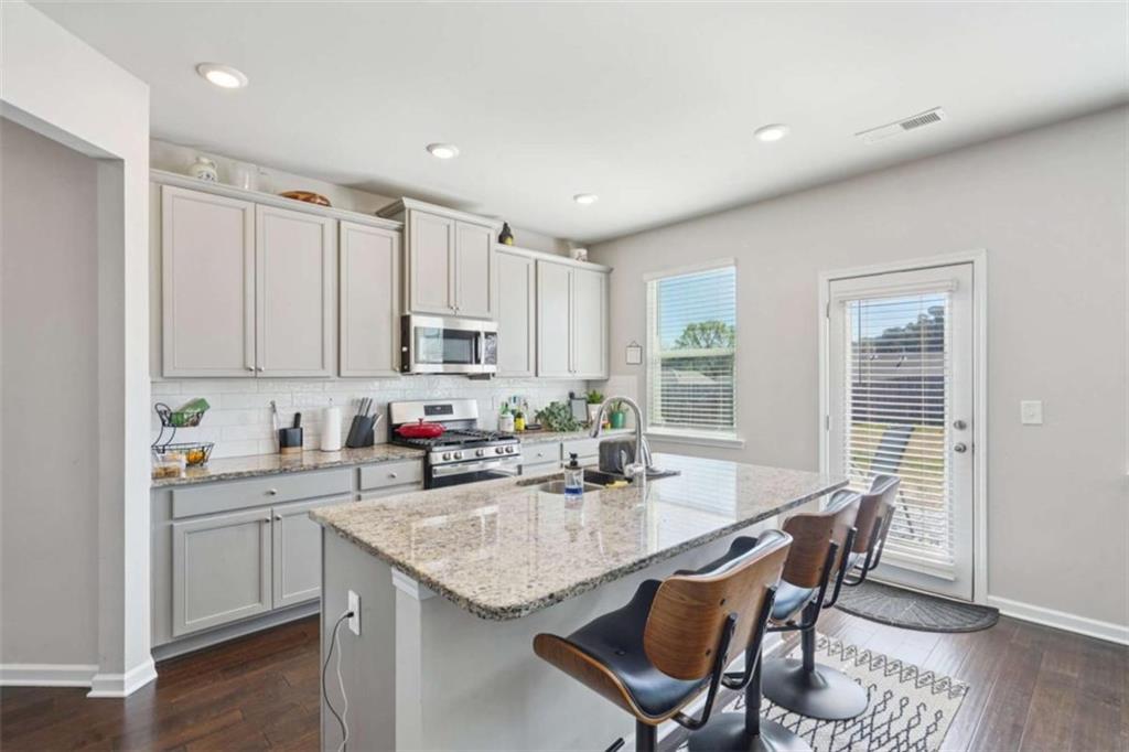 3605 Broadwick Lane Lithonia, GA 30038 - Photo 8 of 41 a kitchen with stainless steel appliances granite countertop a table chairs sink and cabinets