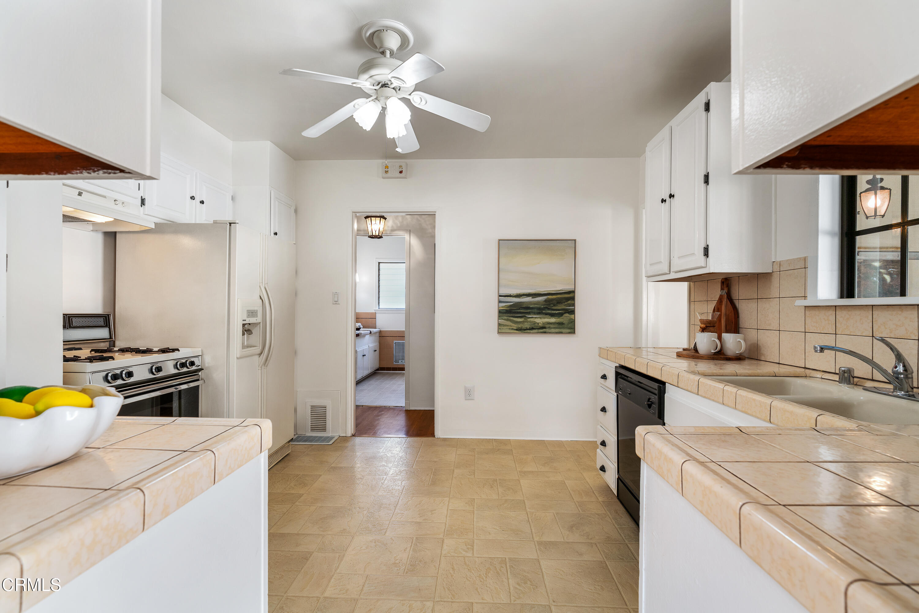 990 Bella Vista Avenue Pasadena, CA 91107 - Photo 7 of 16 a kitchen with stainless steel appliances granite countertop a sink a stove a refrigerator a stove a dining table and chairs with wooden floor
