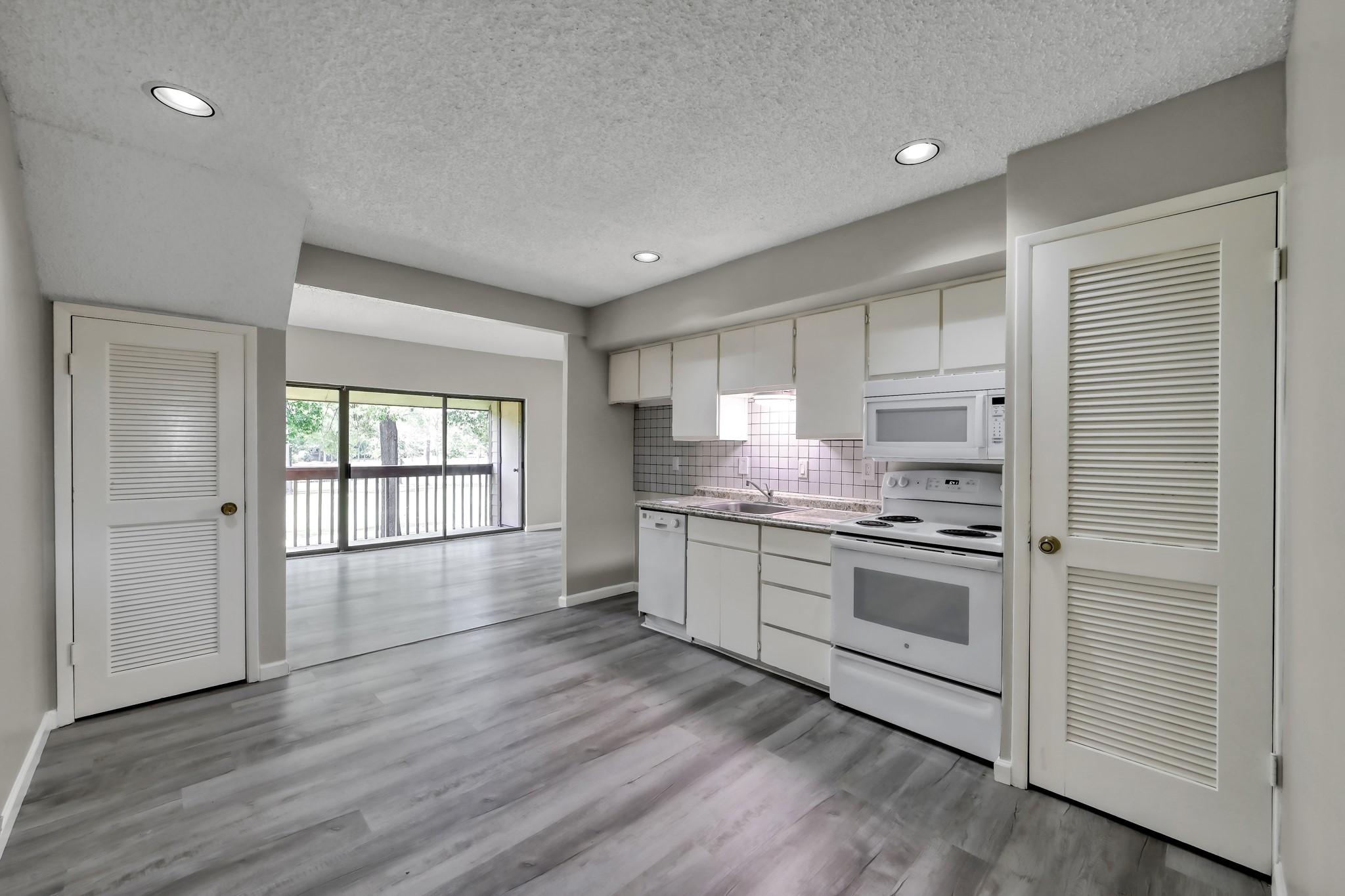 12900 Walden Road, Unit 604F Montgomery, TX 77356 - Photo 5 of 19 a kitchen with stainless steel appliances granite countertop a stove a sink and white cabinets