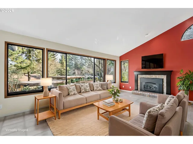a living room with furniture a fireplace and a large window